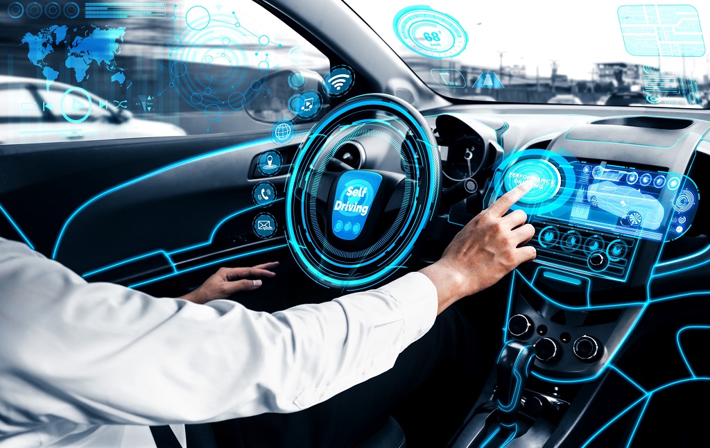 Self-driving autonomous car with relaxed young man sitting at driver seat is driving on busy highway road in the city.